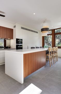 a kitchen with an island counter and bar stools