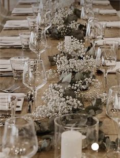 the table is set with many glasses and place settings for dinner guests to sit at