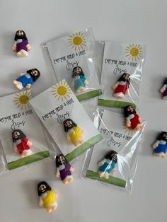 some little figurines are in plastic bags with tags on them that say jesus is here