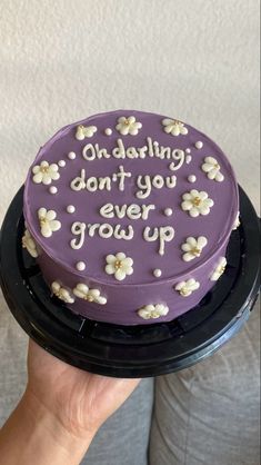 a purple cake with white flowers on it that says, oh dating don't you ever grow up