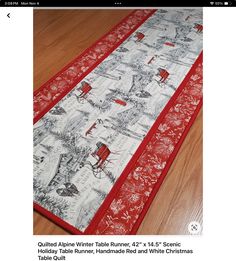 a red and white table runner on a wooden floor with the words quilted alpine winter table runner