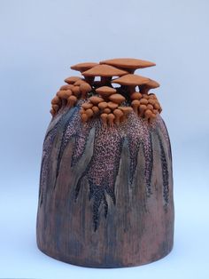 a ceramic vase with rocks and trees on it