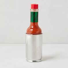 a hot sauce bottle sitting on top of a white table