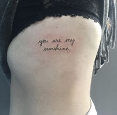 the back of a woman's stomach with a tattoo saying you are my sunshinene