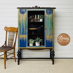 a blue cabinet sitting next to a wooden chair on top of a carpeted floor