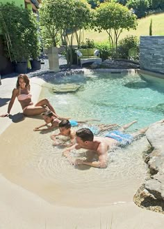 three people in a swimming pool with rocks