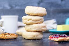 a stack of doughnuts sitting on top of a table next to a cup of coffee