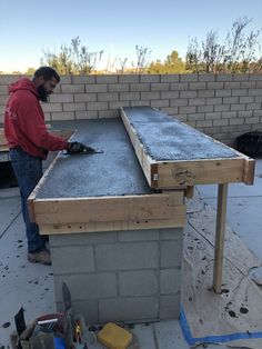 a man sanding concrete on top of a building