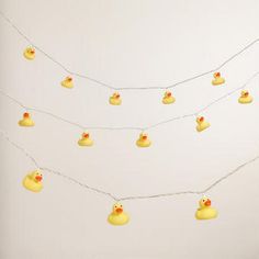 yellow rubber ducks are hanging on a string with white lights in the shape of hearts