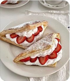 two pastries with strawberries are on a plate