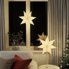 a living room with a white couch and christmas decorations on the windowsill, next to a window sill