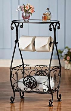 an iron shelf with two rolls of toilet paper on it and flowers in vases