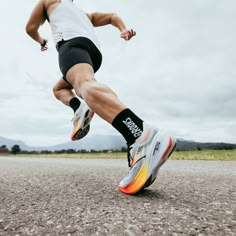 a man is running on the road with his feet in the air and one leg behind him