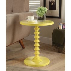 a small yellow table with a vase on it