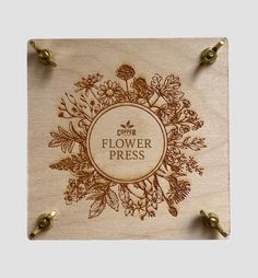 a wooden plaque with the words flower press on it