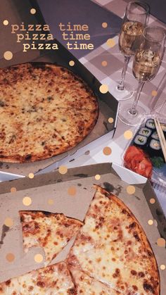 two pizzas in boxes on a table with confetti and wine glasses next to them