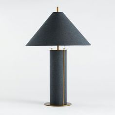 a black lamp with a gold base and a blue shade on the top, sitting on a white surface