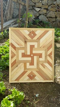 a wooden box sitting on the ground next to some plants