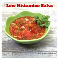 a green bowl filled with soup and garnished with cilantro on top