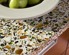 a white bowl filled with green pears on top of a counter