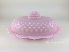 a pink cake plate with a tiara on top