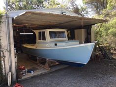 a boat is parked in the garage under a roof over an area with other tools