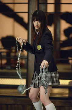 a girl in a school uniform is chained up