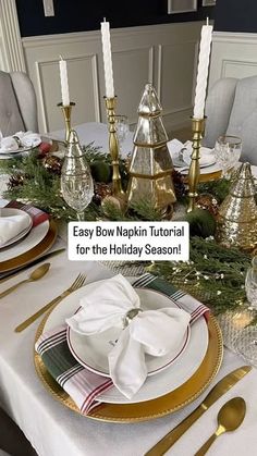 the table is set for christmas dinner with gold and white plates, napkins, silverware and candlesticks