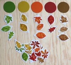 the autumn leaves are cut out and placed next to each other on top of a wooden surface