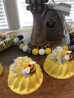 three bees are sitting on top of some yellow plastic cups with beads and decorations around them