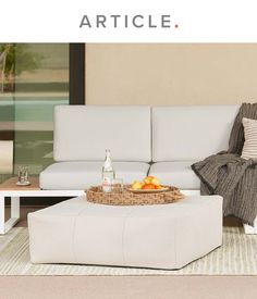 a white couch sitting next to a coffee table on top of a carpeted floor