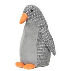 a stuffed penguin sitting on top of a white floor