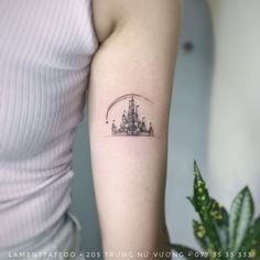 a small castle tattoo on the arm