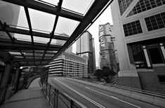 a black and white photo of a city street with tall buildings in the back ground