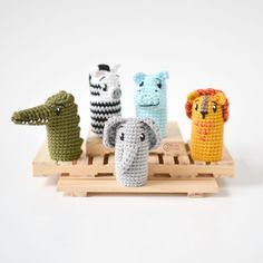 four crocheted animals sitting on top of a wooden tray