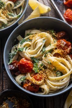 two bowls filled with pasta and vegetables on top of a wooden table