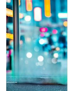 blurry image of traffic lights in the city at night with focus on the ground