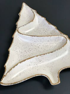 a white ceramic dish with gold trimmings on the edge and a black background