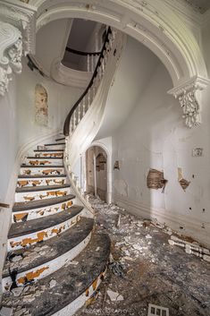 an old run down building with peeling paint on the walls and stairs leading up to it