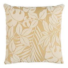 a beige and white pillow with leaves on it