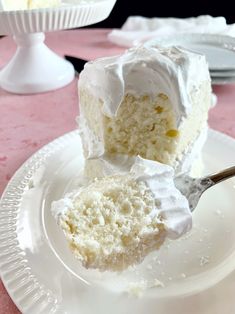 a piece of cake on a white plate with a fork in it and another slice missing