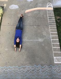 a woman is laying on the ground with her hands in the air