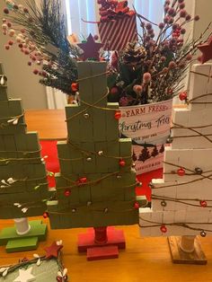 three small wooden christmas trees sitting on top of a table