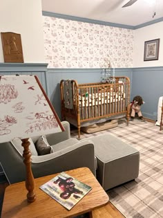 a baby's room is decorated in blue and white with floral wallpaper on the walls