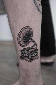 a tattoo on the leg of a man with a record player