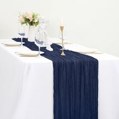 the table is set with white and blue linens