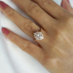 a woman's hand with a diamond ring on top of her left hand,