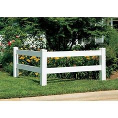 a white fence in front of some flowers