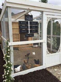 several chickens in a small white coop with a sign on it that says the farm