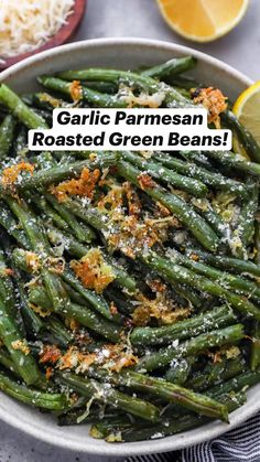 garlic parmesan roasted green beans in a bowl with lemon wedges on the side